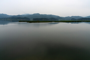 Fototapeta premium Scenic Lake Landscape with Floating Wetland Island and Calm Water Reflection