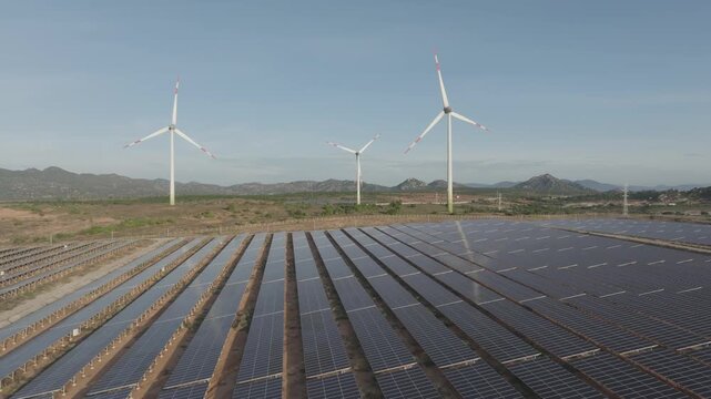 Aerial drone footage of Phuoc Dinh Renewable Energy Complex in Khanh Hoa, Vietnam, featuring solar panels and wind turbines, showcasing clean energy, sustainable power and green technology.