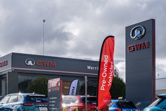 GWM car dealership exterior with pre-owned vehicles banner and signage tower, displaying parked cars in Melbourne, Australia