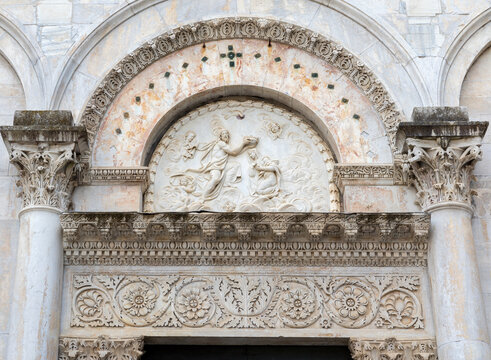 Lucca - The detail of relief of Coronation of Virgin Mary over the main potal of church Chiesa di Santa Maria Fortisportam by unknown artist.
