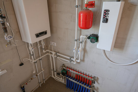 utility wall hosts a gas boiler, red expansion tank, circulation pump, and manifold with blue red valves. PPR pipes and controls complete heating system layout