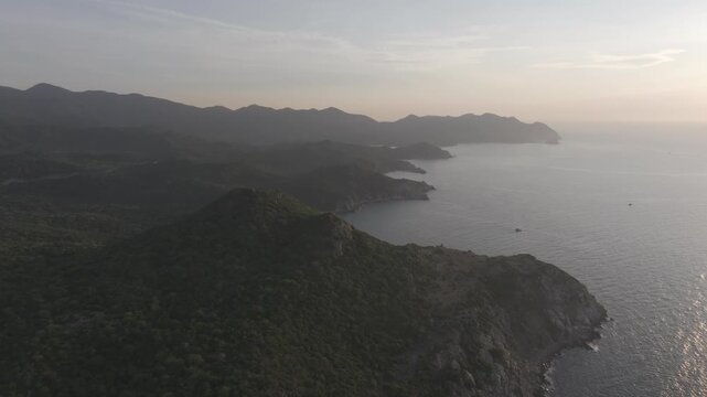 Aerial drone footage of sunrise at Hang Rai, Khanh Hoa, Vietnam, featuring dramatic rocky coastline, turquoise sea, coral reef, golden morning light and breathtaking coastal landscape.