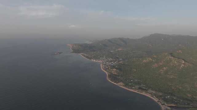 Aerial drone footage of sunrise at Hang Rai, Khanh Hoa, Vietnam, featuring dramatic rocky coastline, turquoise sea, coral reef, golden morning light and breathtaking coastal landscape.