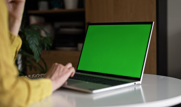 Laptop with green screen chroma key mockup for content replacement.
