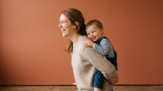 Joyful Mother Carrying Her Happy Baby on Her Back Outdoors