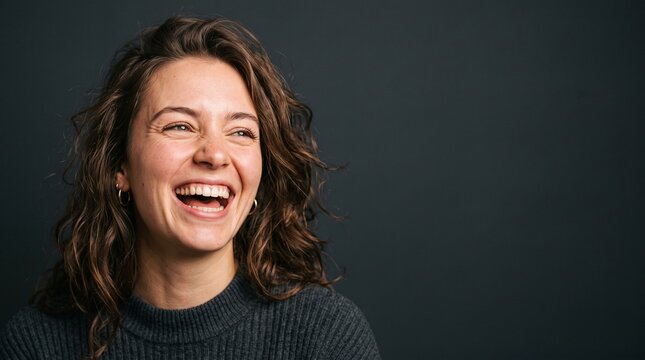 Young woman laughing heartily with eyes closed and a wide smile