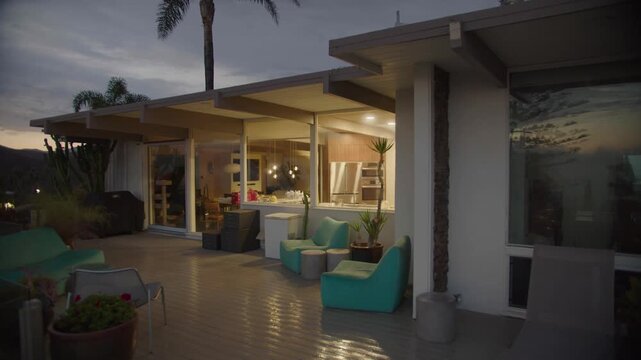 Modern mid century home exterior deck at dusk with scenic views.