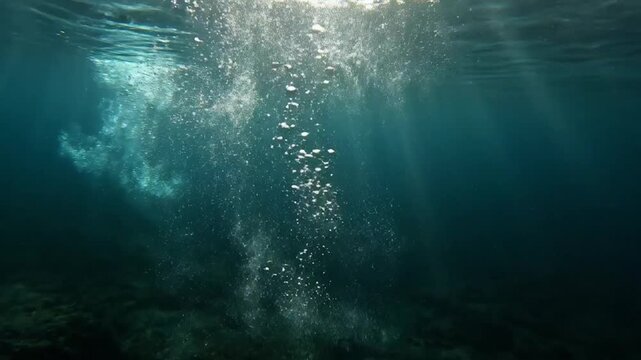 Bubbles Ascending in Deep Blue Sea: Sunlight streams down into the deep blue ocean, illuminating a trail of rising bubbles and underwater currents, creating a mesmerizing and tranquil aquatic scene.