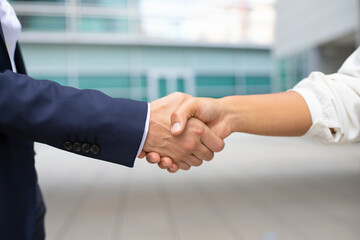 Closeup shot of business handshake. Cropped shot of two people wearing formal suits shaking hands. Business handshake concept © William
