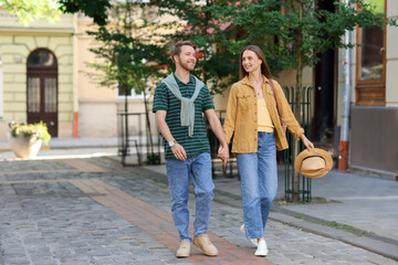 Obraz premium Couple holding hands together while walking outdoors, space for text
