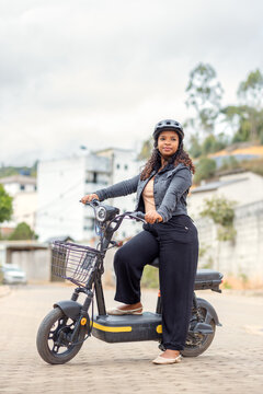 Young Black Brazilian woman with an electric bicycle, representing sustainable commuting, clean urban mobility, and eco-friendly transportation for everyday travel.