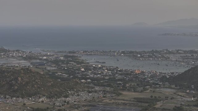 Aerial drone footage of sunset over Dam Nai Lagoon, Khanh Hoa, Vietnam, featuring golden reflections, tranquil waters, fishing boats and breathtaking coastal landscape at golden hour.