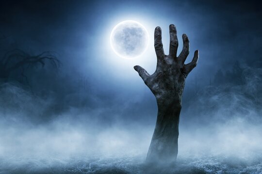 Creepy Zombie Hand Rising from Ground in Foggy Night Horror Halloween Background