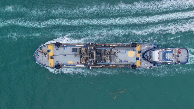 Aerial view bunkering vessel. Industrial petrochemical tanker. Fuel tanker vessel. Bunkering tanker aerial top view. Industrial vessel cruising through the sea. Transport fuel or chemicals