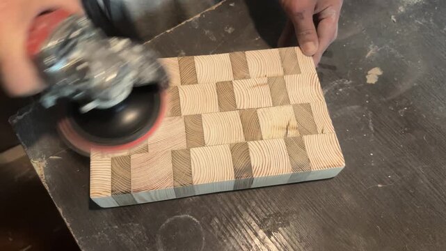 Sanding an end-grain wooden kitchen board with an interesting pattern. . High quality 4k footage