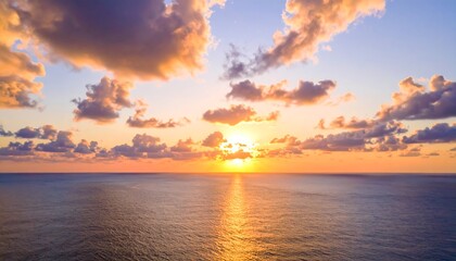 Fototapeta premium Golden sunset over calm water with clouds and reflections.