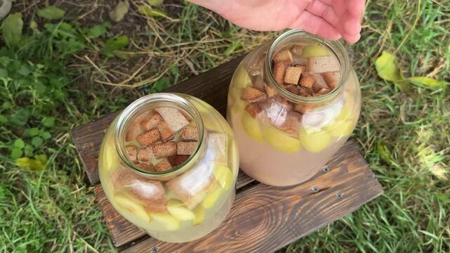 Preparing a refreshing summer kvass with dark bread croutons and fruit. High quality 4k footage