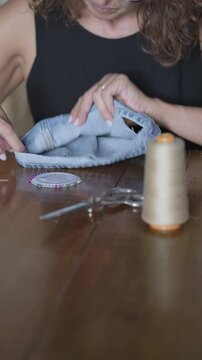 Hand sewing denim jeans hem with thimble scissors pins vertical- Rec709 Color Graded
