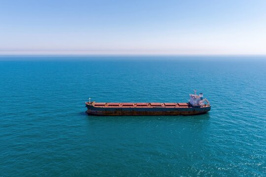 Large bulk carrier cargo ship sailing across the deep blue open ocean
