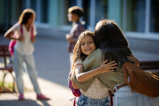 Mother greets daughter in schoolyard