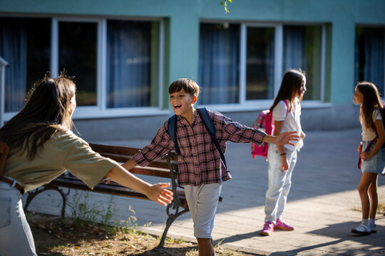 Mother greets son in schoolyard