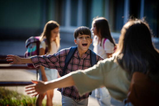 Mother greets son in schoolyard