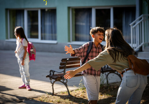 Mother greets son in schoolyard