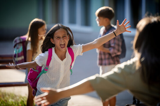 Mother greets daughter in schoolyard