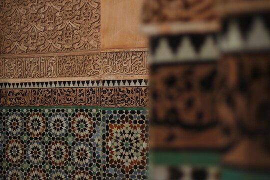 Intricate Moroccan zellige mosaic tiles and detailed carved plaster wall architecture
