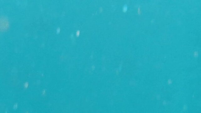 Underwater, water, bubbles, clear blue ocean water creates abstract background texture with subtle movement
