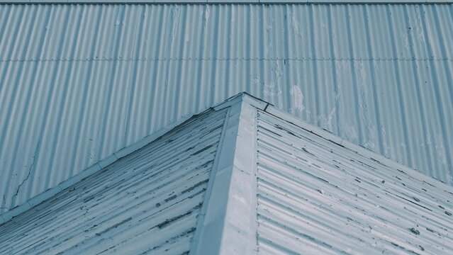 Modern building structure with prominent edges and metallic surfaces. Architecture and construction, industrial design. Cladding and roofing materials.
