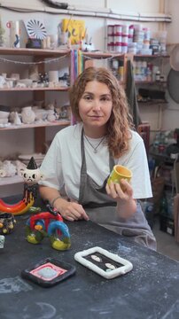 Ceramic Artist Displaying Handcrafted Pottery in Studio