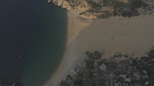 Aerial drone footage of sunrise over Mui Dinh Lighthouse and pristine beach in Khanh Hoa, Vietnam, showcasing golden morning light, dramatic coastline, turquoise sea and iconic coastal landmark.