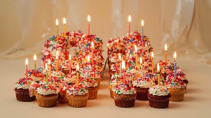 Obraz premium Birthday cupcakes with lit candles, colorful sprinkles, and festive decorations. Celebration and party concept. Cake and baking quantity. The concept of birthday festivities.