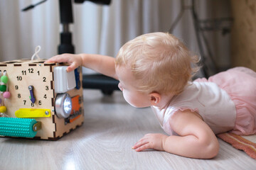 Naklejka premium Child plays with a learning toy on the floor