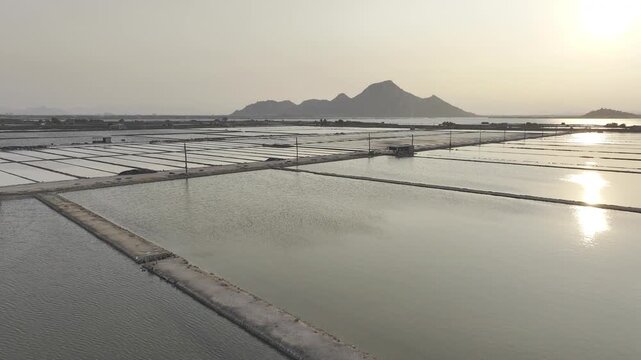 Aerial drone footage of Phuong Cuu Salt Fields in Khanh Hoa, Vietnam, showcasing traditional sea salt production, geometric salt ponds, coastal landscape and sustainable local industry.