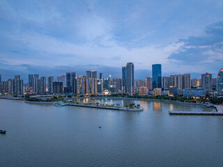 Obraz premium Zhanjiang Jinshawan bay evening city skyline with river view and illuminated skyscrapers