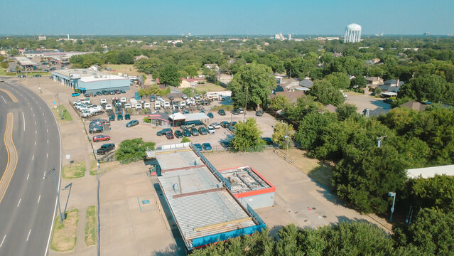 Plymouth Park industrial commercial sectors feature weathered corrugated metal roofs on warehouse facilities. Paved parking lots major transit roadways border commercial zones, Irving, Texas