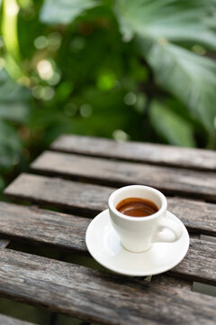 half drink coffee in a small white cup in the garden