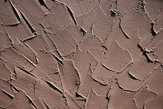 Abstraktes Motiv mit brauner Betonwand und Muster als Hintergrund