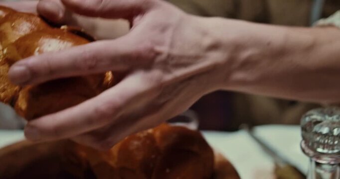 Breaking Traditional Challah Bread at a Shabbat Dinner Table