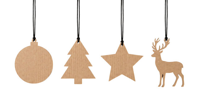 Set of four rustic cardboard christmas ornaments hanging on black strings against a plain white background