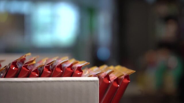 A Close-Up View of Colorful Snack Packages Arranged Neatly in a Display Box, Highlighting the Careful Arrangement of Each Item for Optimal Appeal and Convenience.