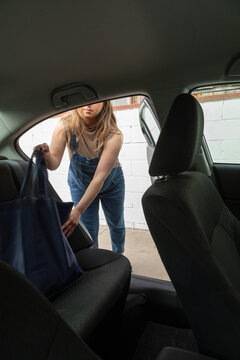 Pregnant woman with groceries in her car