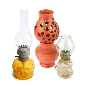 Vintage oil lamps and ceramic lantern isolated on white background. Collection of retro kerosene lamps and terracotta candle holder.