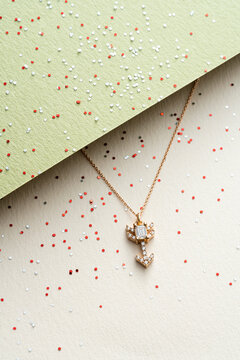 Gold Arrow Pendant Necklace on Geometric Background 