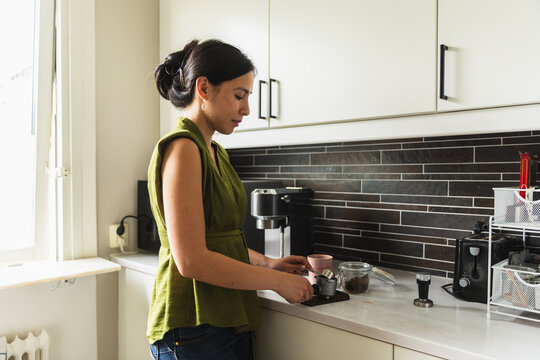Young Woman Preparing Coffee in Modern Kitchen