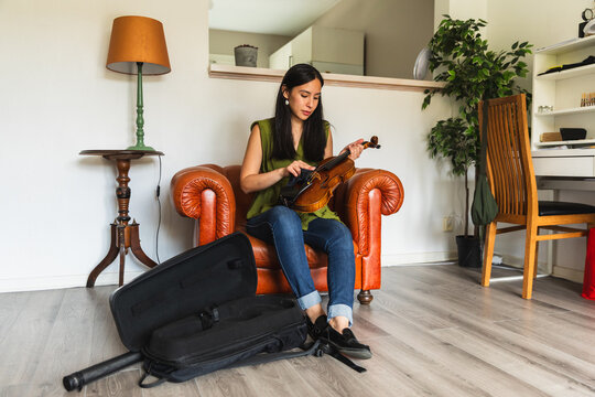 Female Musician Cleaning Violin with Microfiber Cloth