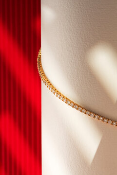 Gold Crystal Bracelet on White Display Prop with Red Backdrop