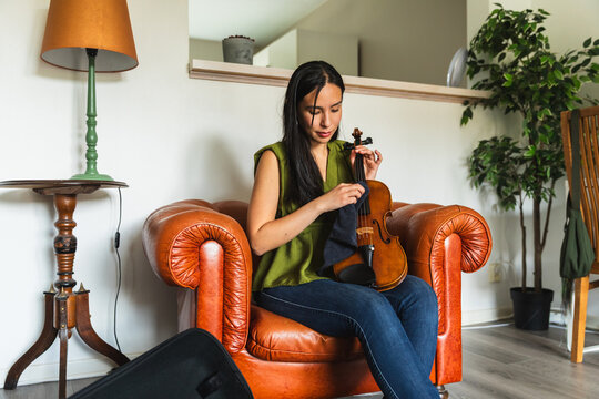 Female Musician Cleaning Violin with Microfiber Cloth
